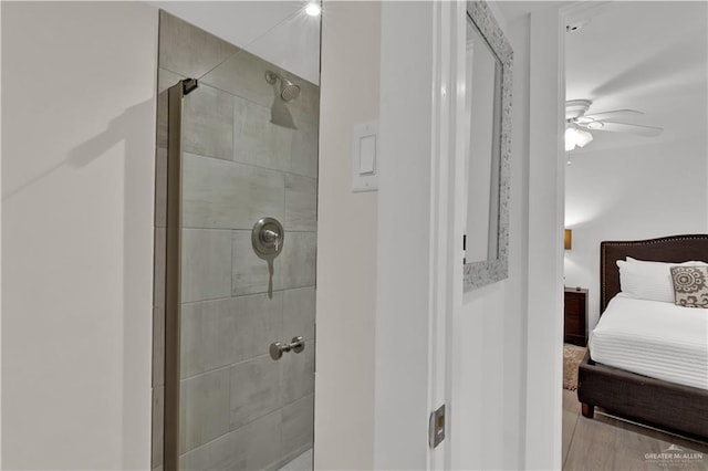 ensuite bathroom with a shower stall, ceiling fan, and ensuite bathroom