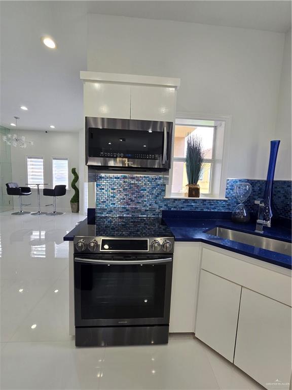 6503 Fountain Way S, Padre Island, TX 78597 - kitchen with appliances with stainless steel finishes, white cabinetry, a sink, backsplash, and recessed lighting