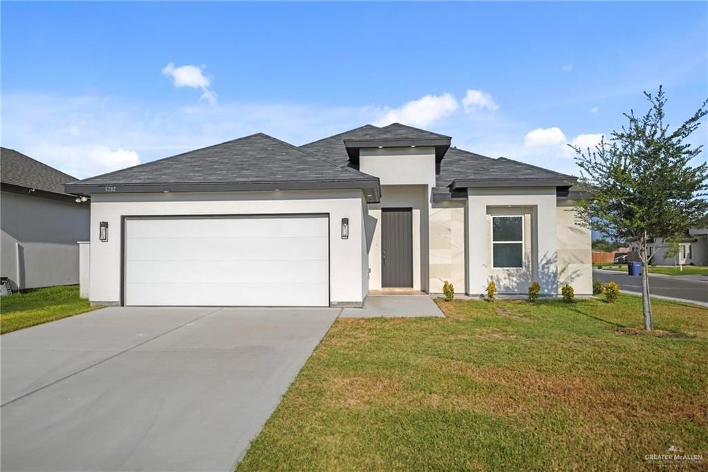 view of front of home featuring a front yard and a garage