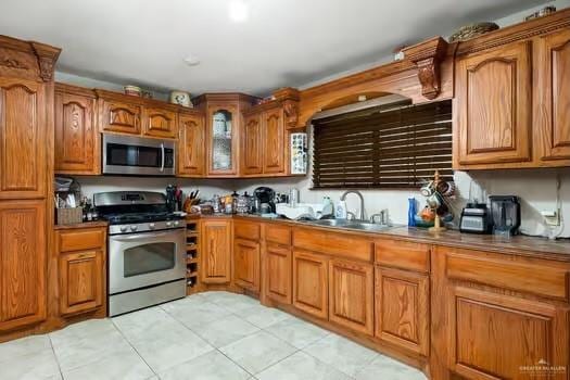 kitchen featuring light tile patterned flooring, stainless steel appliances, and sink