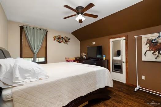 bedroom with ceiling fan, dark hardwood / wood-style flooring, and lofted ceiling