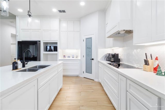 1801 Stardust Ln, Edinburg, TX 78541 - kitchen with black electric cooktop, light countertops, white cabinetry, custom exhaust hood, and decorative backsplash