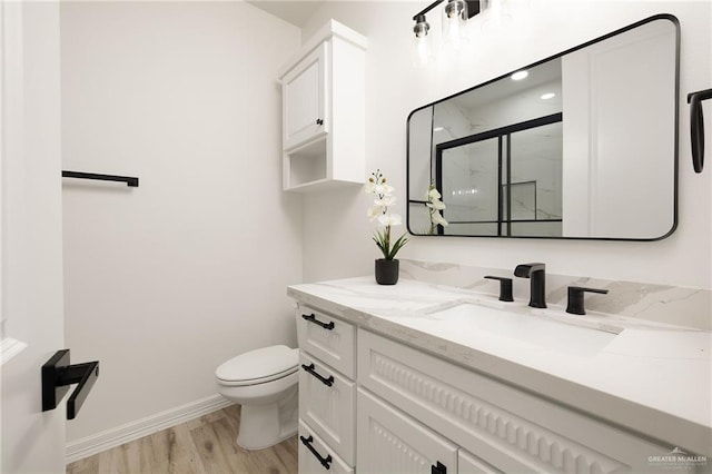 bathroom featuring hardwood / wood-style flooring, vanity, toilet, and an enclosed shower