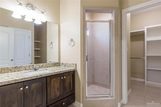 2805 E Garfield Ave, Alton, TX 78573 - full bathroom with a stall shower, tile patterned floors, a spacious closet, and baseboards
