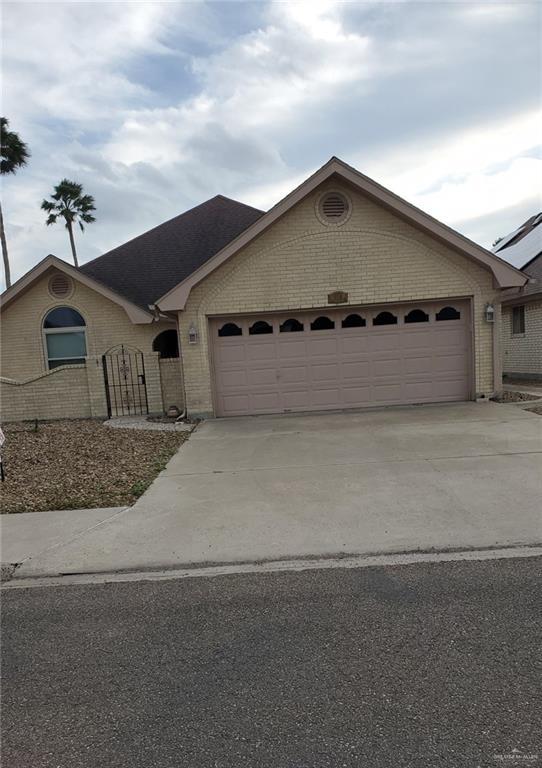 view of front of property featuring a garage, concrete driveway, and brick siding