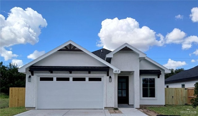view of front of house featuring stucco siding, a garage, fence, and concrete driveway