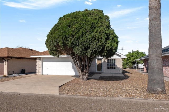 view of front facade featuring concrete driveway, an attached garage, and brick siding