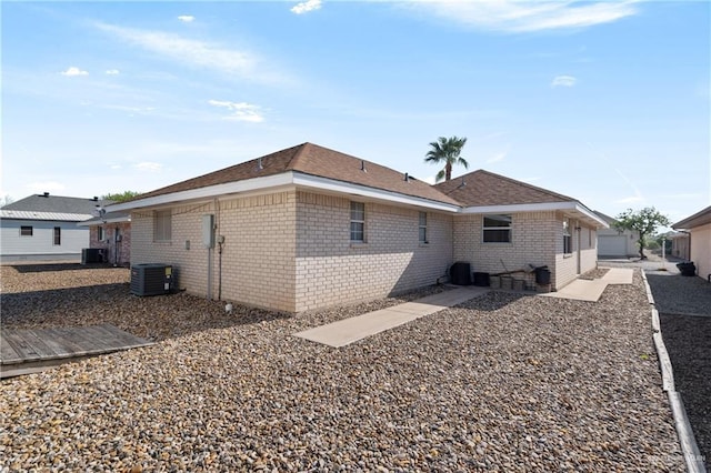 back of house with cooling unit and brick siding