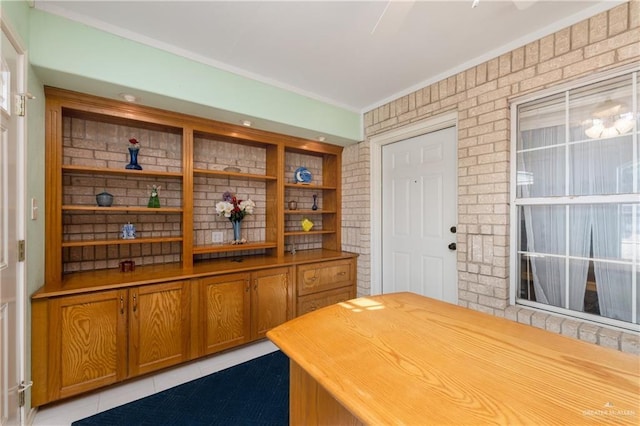 bar featuring tile patterned floors, brick wall, and ornamental molding