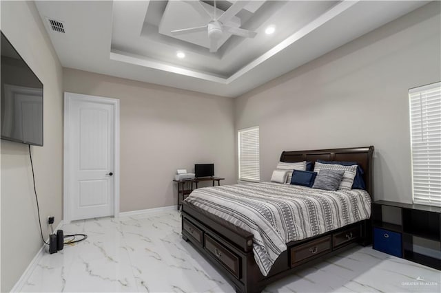 bedroom featuring ceiling fan and a tray ceiling