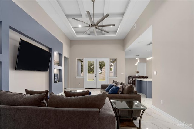 living room with coffered ceiling, beam ceiling, french doors, and a towering ceiling