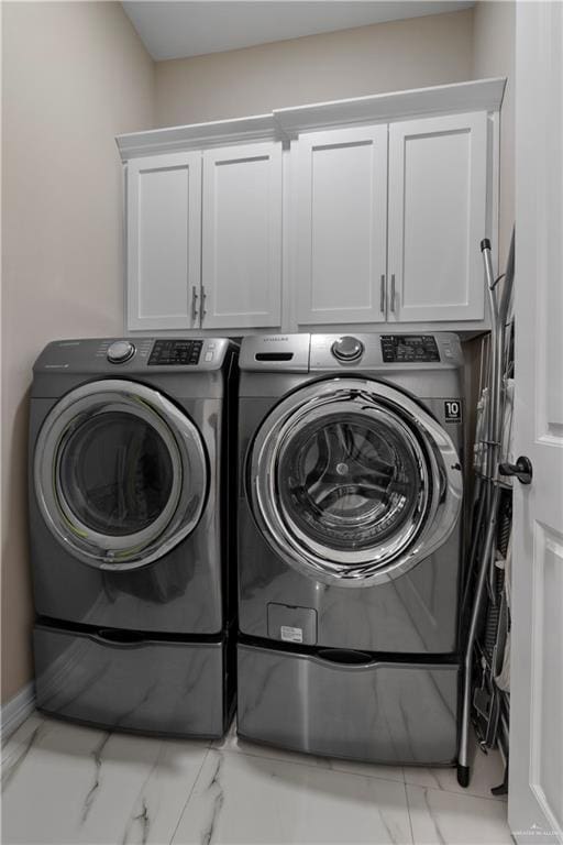 laundry room with cabinets and washer and clothes dryer