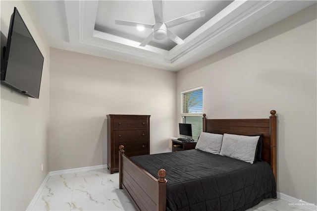 bedroom with ceiling fan and a tray ceiling