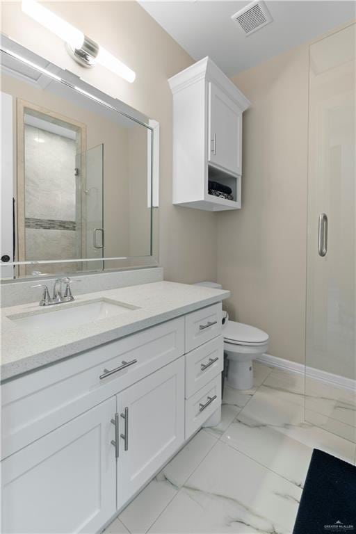 bathroom featuring vanity, toilet, and a shower with shower door