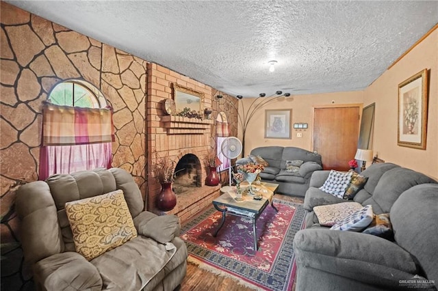 living room featuring a textured ceiling and a brick fireplace