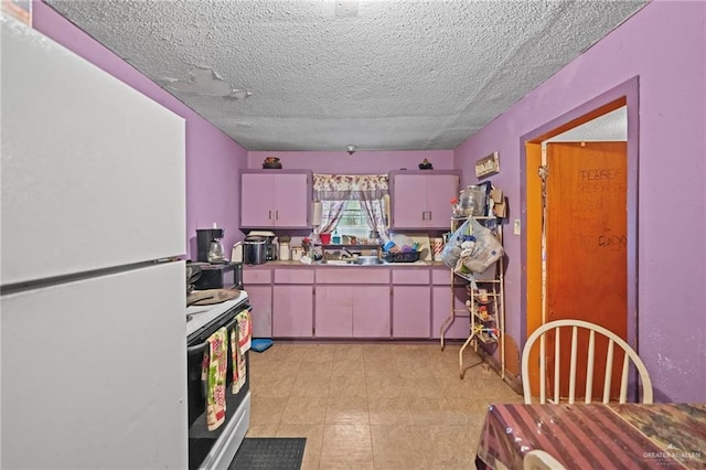 kitchen with a textured ceiling, sink, and white appliances