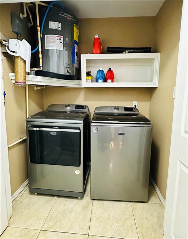 524 S Mile 2 W, Mercedes, TX 78570 - clothes washing area featuring washer and dryer, baseboards, and laundry area