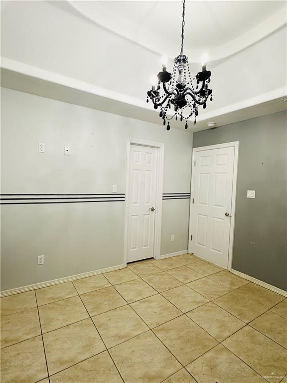 524 S Mile 2 W, Mercedes, TX 78570 - unfurnished room featuring light tile patterned floors, baseboards, and a notable chandelier