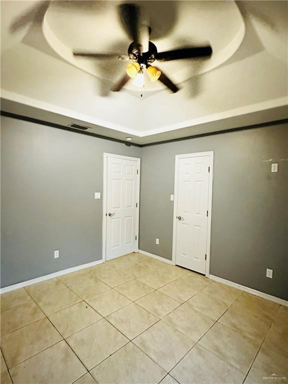 524 S Mile 2 W, Mercedes, TX 78570 - spare room featuring light tile patterned floors, baseboards, visible vents, a tray ceiling, and ceiling fan