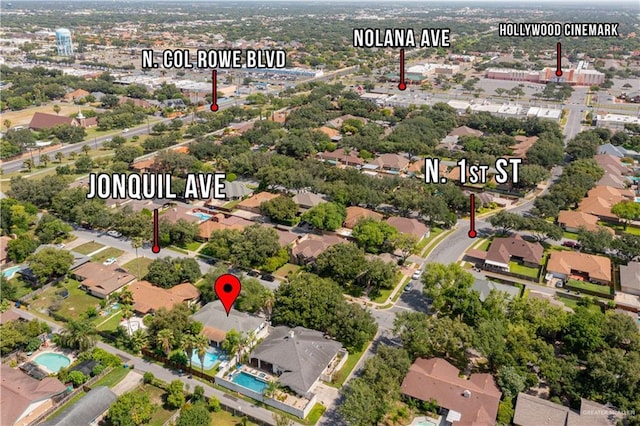 aerial view of property's location featuring a pool area and nearby suburban area