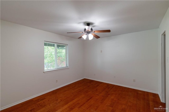 spare room featuring a ceiling fan, baseboards, and wood finished floors