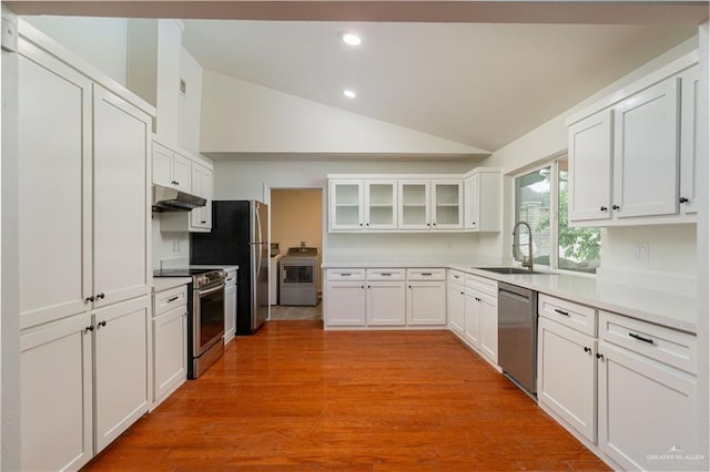 kitchen with appliances with stainless steel finishes, under cabinet range hood, lofted ceiling, a sink, and recessed lighting