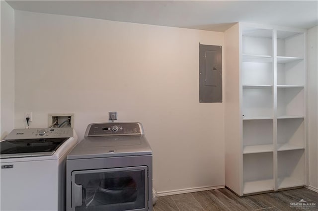 clothes washing area with electric panel, washing machine and dryer, dark wood-type flooring, and baseboards