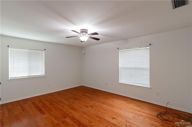 unfurnished room with a ceiling fan, light wood-type flooring, and baseboards