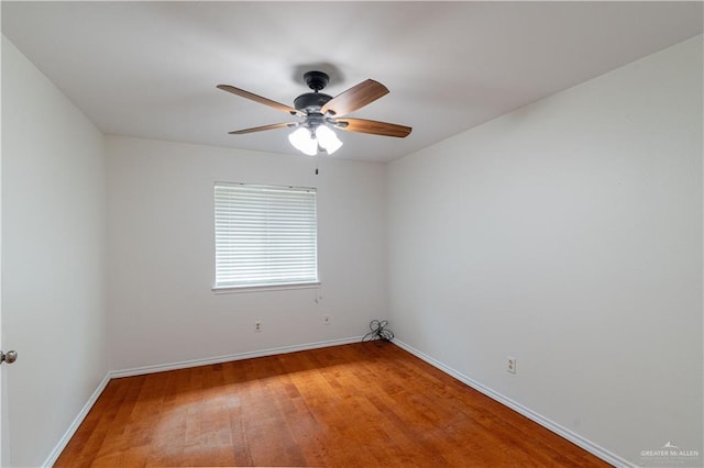 empty room with light wood finished floors, baseboards, and a ceiling fan