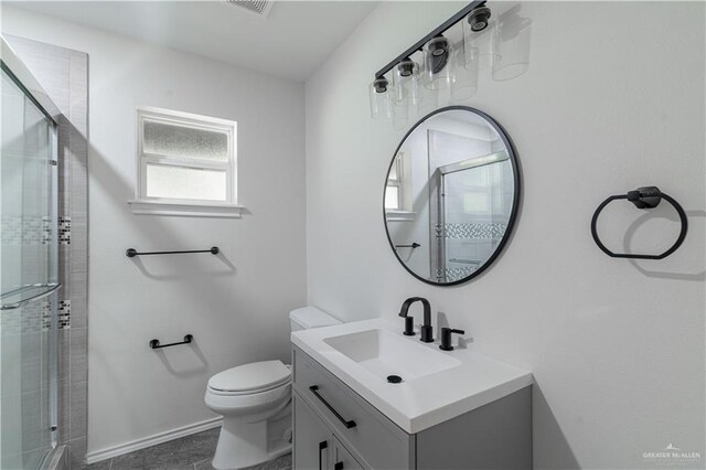 full bathroom with a stall shower, toilet, vanity, and baseboards