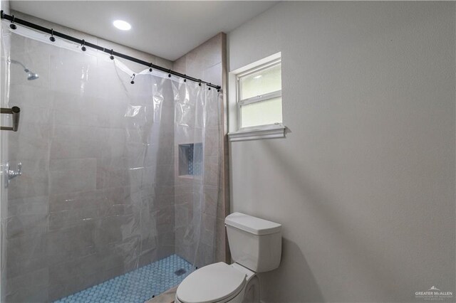 full bathroom featuring toilet, tiled shower, and recessed lighting