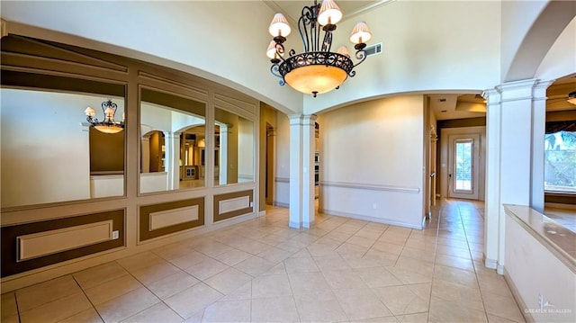 unfurnished dining area featuring visible vents, light tile patterned floors, and decorative columns