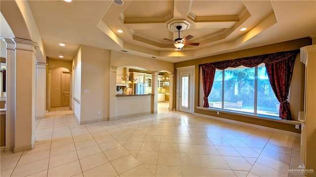 unfurnished room featuring arched walkways, light tile patterned flooring, decorative columns, and a ceiling fan