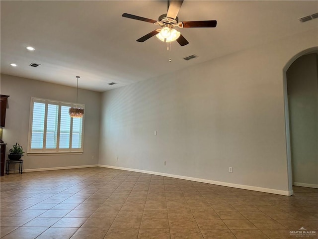 unfurnished room with ceiling fan with notable chandelier and light tile patterned flooring