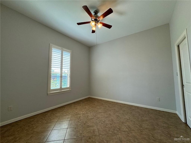 tiled empty room featuring ceiling fan