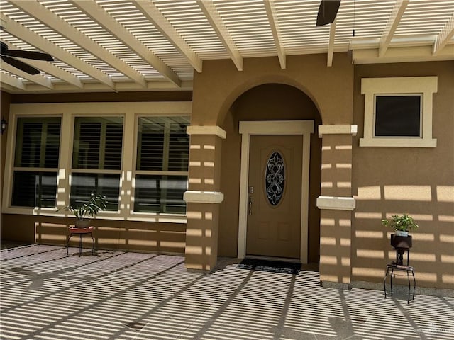 property entrance with a pergola and ceiling fan