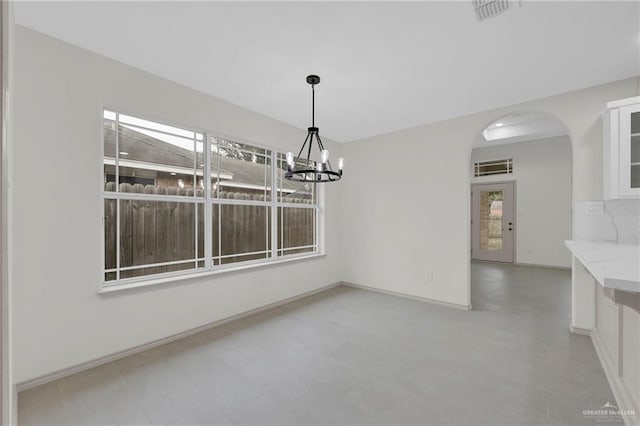 3621 Xenops Ave, Mcallen, TX 78504 - unfurnished dining area featuring visible vents, arched walkways, baseboards, and an inviting chandelier