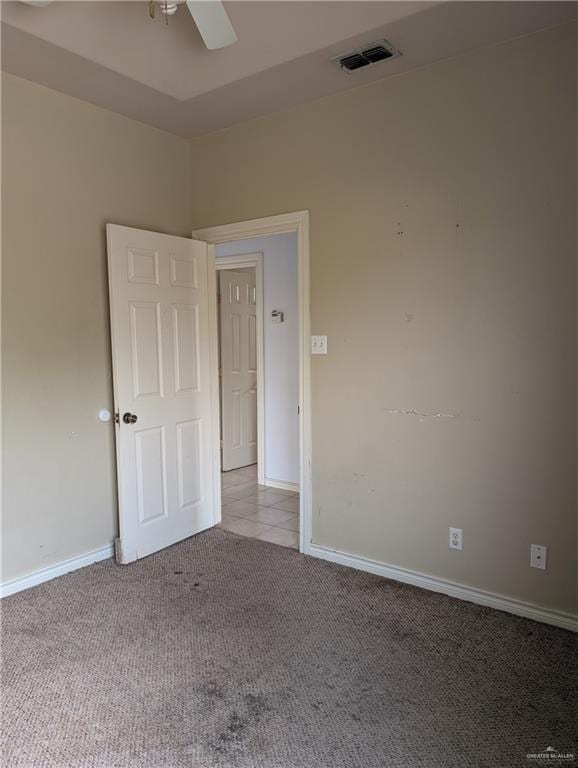 unfurnished room with a ceiling fan, light carpet, visible vents, and baseboards