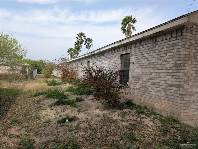 view of side of home featuring brick siding