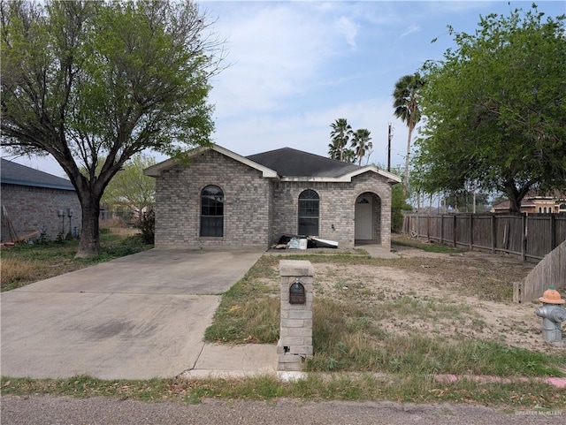 view of front of property featuring brick siding and fence