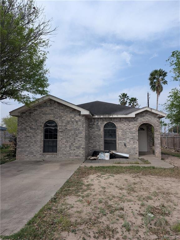 view of front facade featuring brick siding and fence