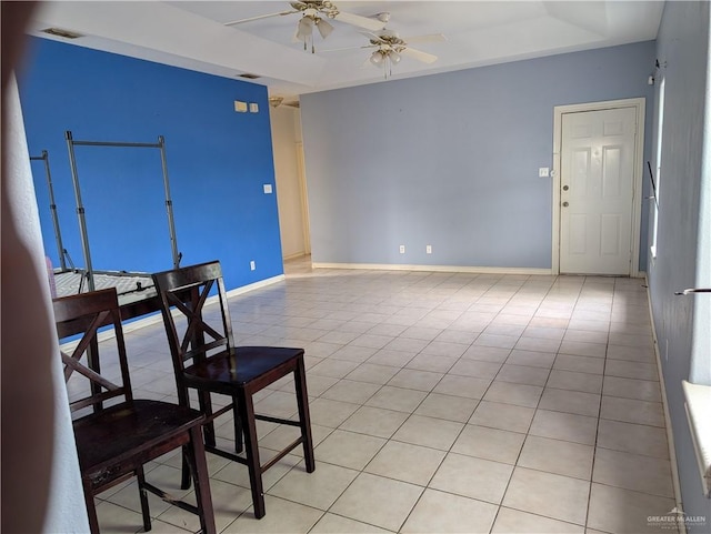 interior space featuring light tile patterned floors, a raised ceiling, visible vents, and baseboards