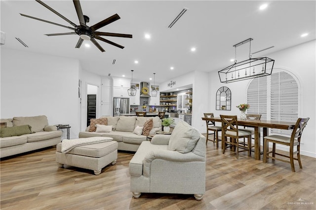 living room featuring ceiling fan and light hardwood / wood-style floors