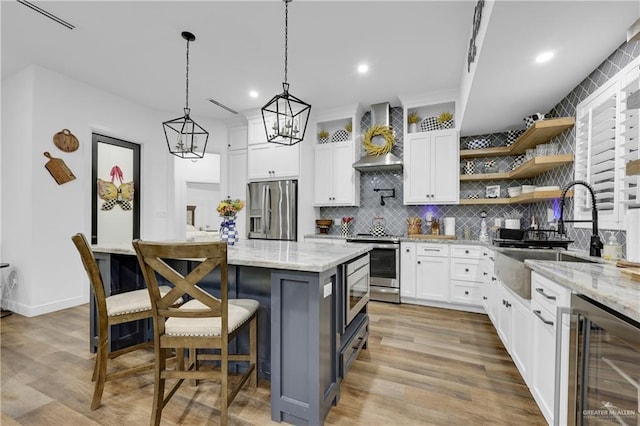 kitchen with sink, stainless steel appliances, white cabinetry, and wine cooler