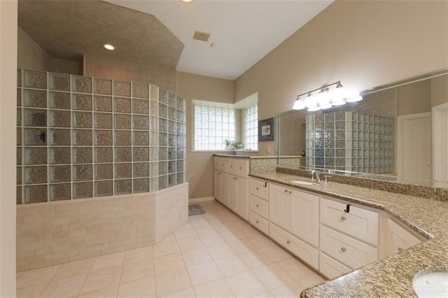 bathroom with tile patterned floors, vanity, and walk in shower