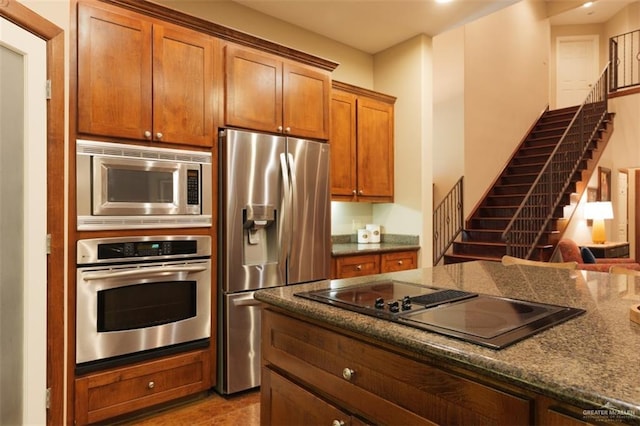 kitchen featuring dark stone countertops and appliances with stainless steel finishes