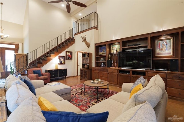 living room with ceiling fan with notable chandelier and a towering ceiling