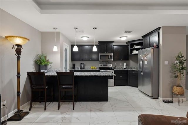 kitchen featuring stainless steel appliances, light stone countertops, hanging light fixtures, and a kitchen bar