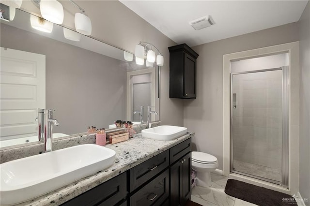 bathroom featuring vanity, a shower with door, and toilet