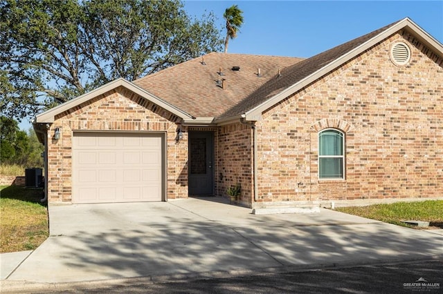 view of front of property with a garage and central air condition unit